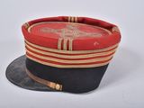 red and black military hat with gold trim on white background