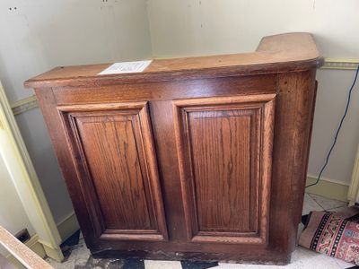 a wooden cabinet that is in the corner of a room