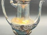 a silver and blue tea pot on a table