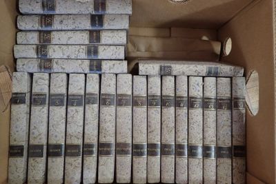 beaucoup de livres dans une boîte posée sur le sol