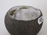 a small bowl with a tag on it sitting on a table