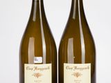 deux bouteilles de vin posées l'une à côté de l'autre sur une surface blanche