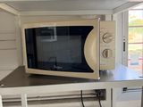 a microwave sitting on top of a shelf in a kitchen