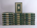 several green books stacked on top of each other on a white surface