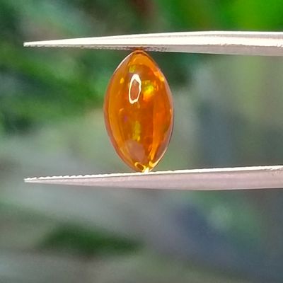 un gros plan sur un bijou tenu par une pince