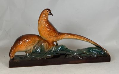 une figurine représentant un faisan et un faisanau, posée sur un socle en bois