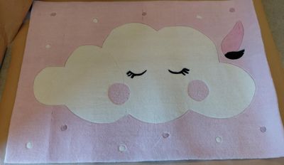 un oreiller orné d'un nuage, posé par terre