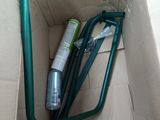 a box with a green handle and a tube in it
