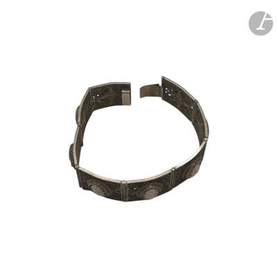 Le bracelet est en métal et présente un motif très travaillé.