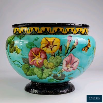 un vase orné de fleurs peintes, posé sur un socle