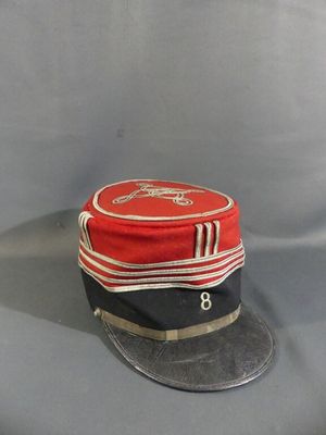 a red and black hat sitting on top of a gray table