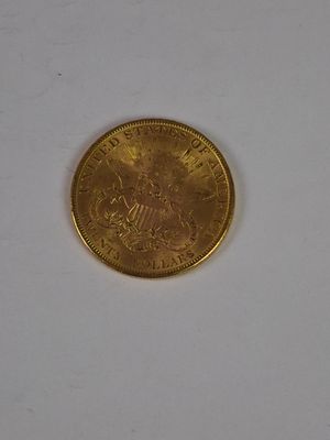 a close up of a gold coin on a white surface