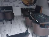 tables and chairs in a restaurant with a wall mural on the wall