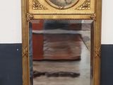 un miroir doré sur lequel figure l'image d'un homme