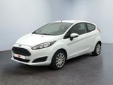 La Ford Fiesta blanche est garée dans une pièce au sol noir.