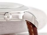 a close up of a watch with a brown leather strap