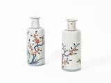 two small vases with flowers on them on a white surface