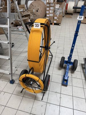 a yellow hose on a cart in a warehouse