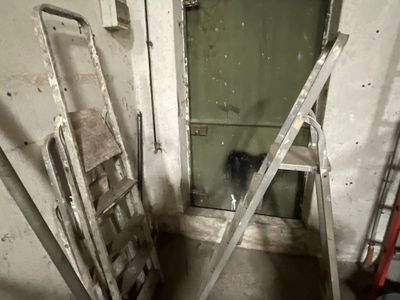 deux échelles appuyées contre un mur dans une pièce