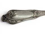 a silver spoon that is sitting on a white surface