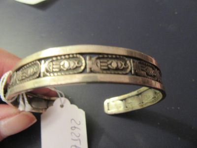 une personne tenant un bracelet en argent muni d'une étiquette