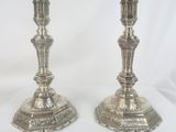 pair of silver candlesticks with ornate designs on each of them
