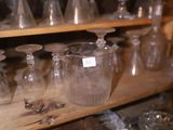 de nombreux vases en verre posés sur une étagère dans une pièce