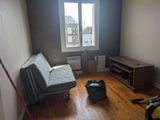 a couch in the corner of a room with a window in the background
