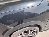 a close up of a black car with a cat on it ' s side