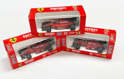 trois Ferrari rouges dans une boîte posée sur une surface blanche