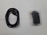 a black cord and a charger on a white table