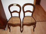 two wooden chairs sitting next to each other on a hard wood floor