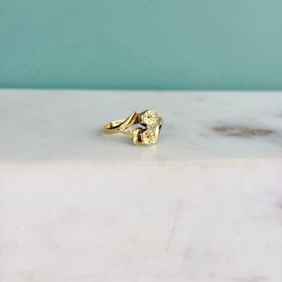 une photo d'une bague en or posée sur un comptoir en marbre