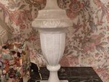 a lamp that is sitting on a table with a vase