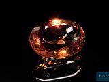 a close up of a large orange diamond on a black surface