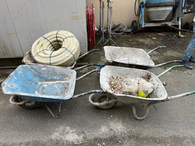 three wheelbarrows that are sitting on the ground