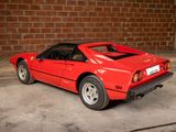 a red sports car parked in front of a brick wall