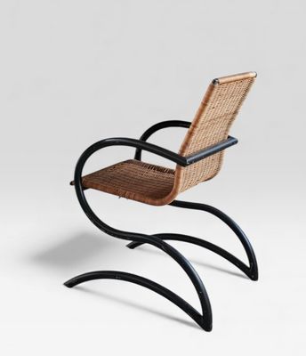 une chaise en bois avec des pieds en métal noir et une assise en osier