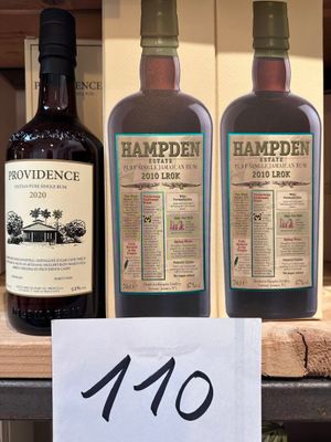 trois bouteilles d'alcool sont posées sur une étagère dans un magasin