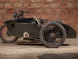a black motorcycle with a side car parked in front of a brick wall