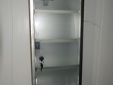 une petite armoire dans un coin d'une petite salle de bains