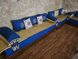 an image of a living room with blue couches and pillows