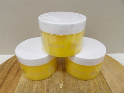 trois pots de peinture jaune et blanche posés sur une planche à découper en bois
