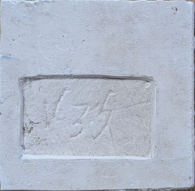 une plaque en pierre représentant un cheval, fixée sur un mur de briques