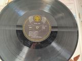 a record sitting on top of a table with a clock on it