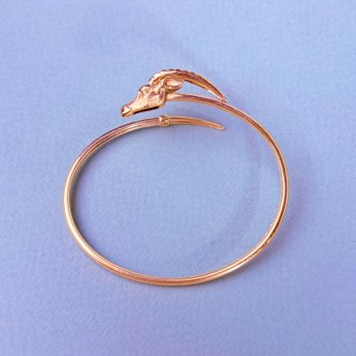 un gros plan d'une bague en or ornée d'un oiseau