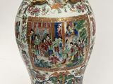 a large vase with a painting on it sitting on a table