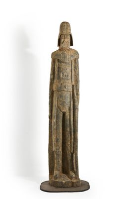 an old wooden statue of a man with a hat and a robe