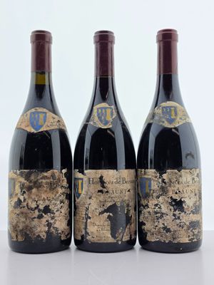 trois bouteilles de vin posées sur une table l'une à côté de l'autre