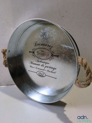 une plaque métallique entourée d'une corde, posée sur une table